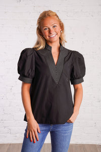 Black v-neck top with white stitching detail