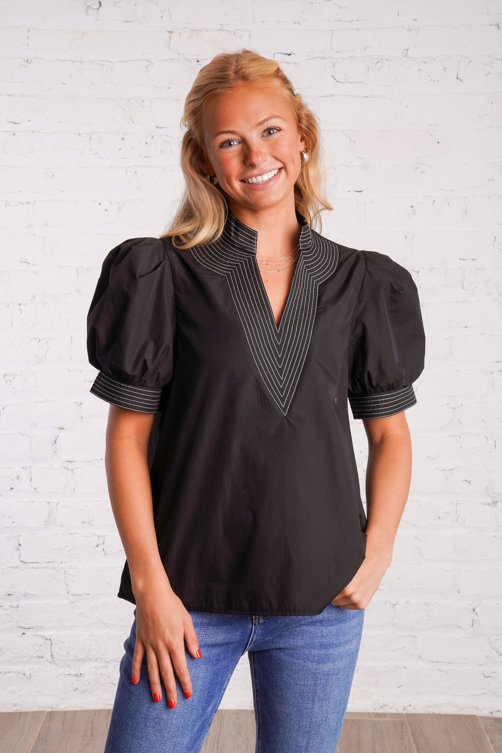 Black v-neck top with white stitching detail