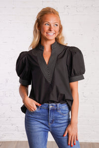 Black v-neck top with white stitching detail