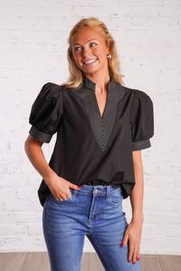 Black v-neck top with white stitching detail