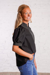 Black v-neck top with white stitching detail
