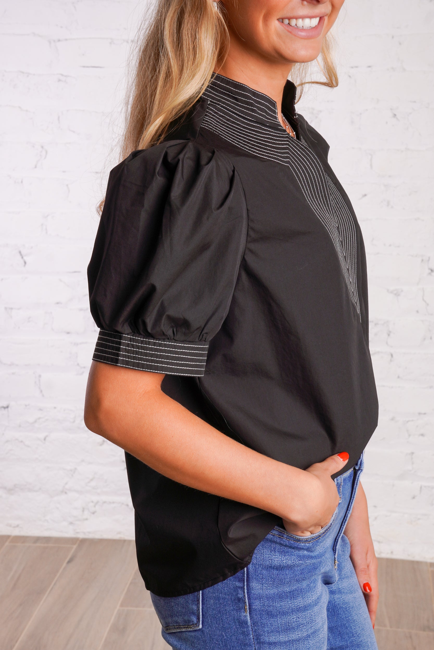 Black v-neck top with white stitching detail