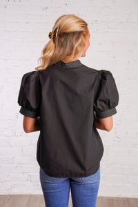 Black v-neck top with white stitching detail
