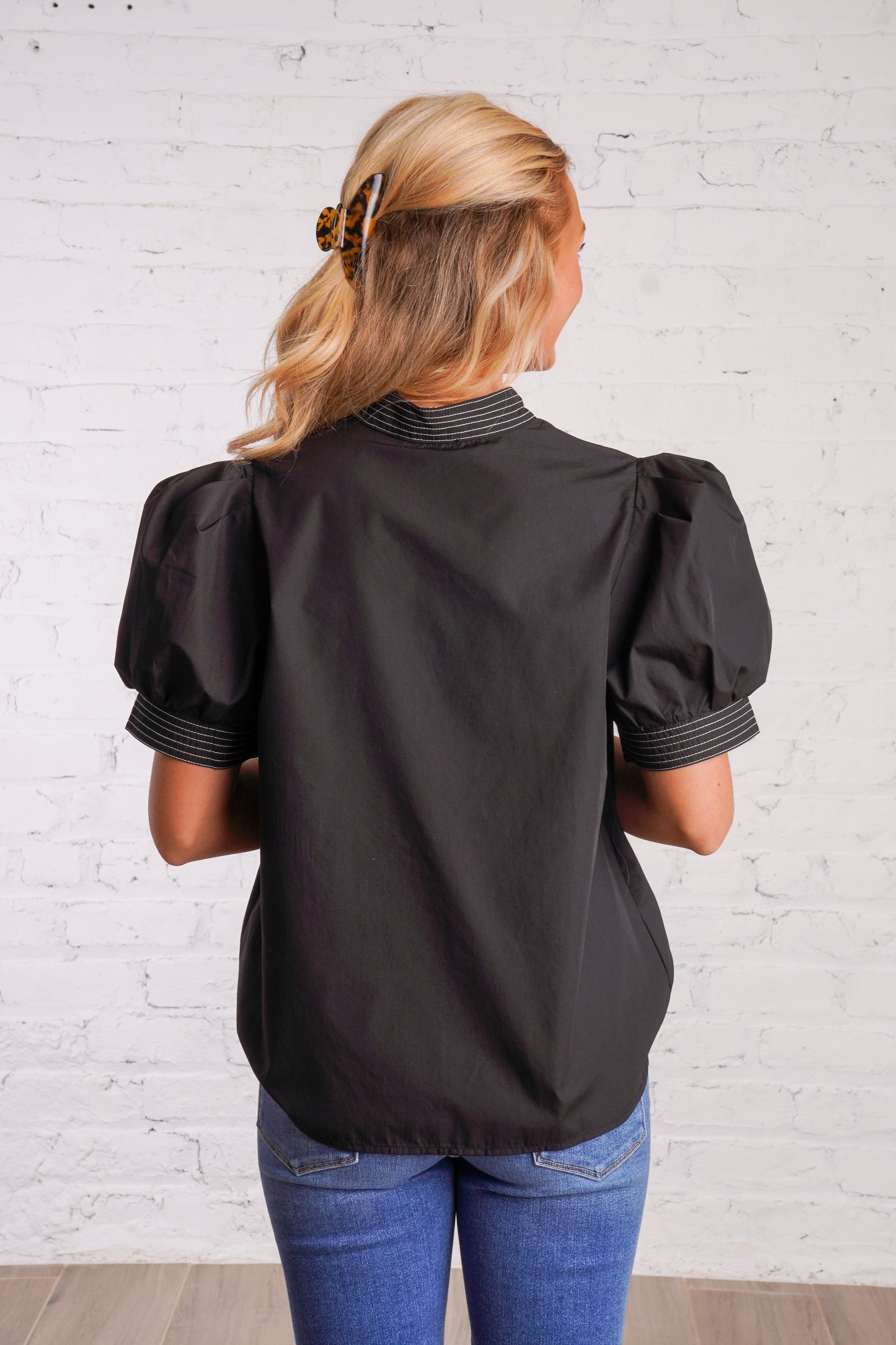Black v-neck top with white stitching detail