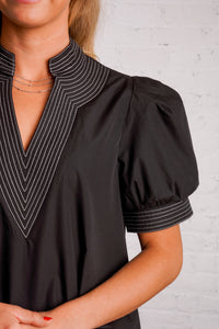 Black v-neck top with white stitching detail