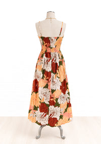 A sleeveless maxi dress with a floral print, displayed on a dress form mannequin against a white background. 