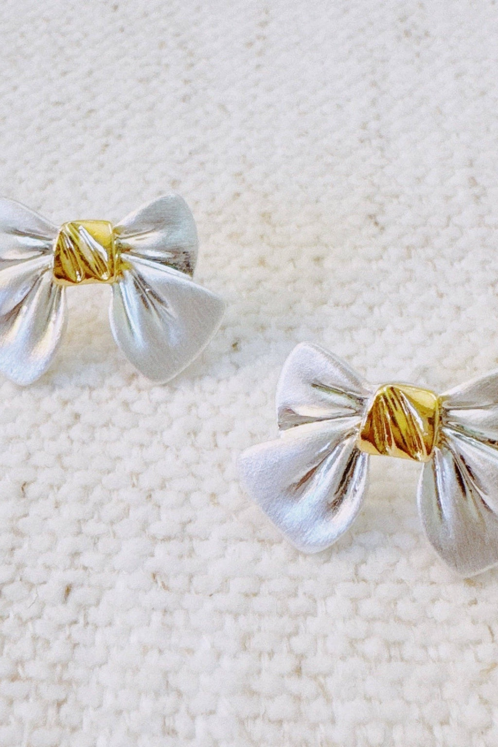 Silver bow-shaped earrings with gold centers 