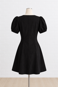 A black short puff-sleeve dress displayed on a mannequin 