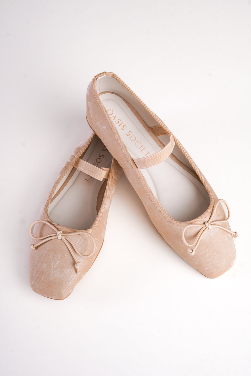 Pair of beige ballet flats with bow details on a white background