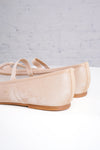 Pair of beige ballet flats on a light gray background