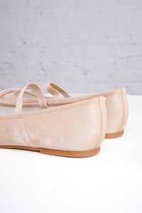 Pair of beige ballet flats on a light gray background