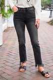model is wearing black, cropped, denim jeans with distressed hems 