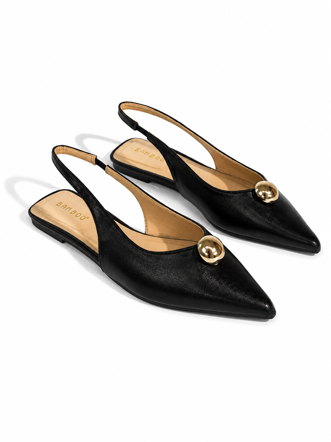 A pair of black pointed-toe slingback flats with gold-tone circular hardware on the vamp, shown on a clean white background.