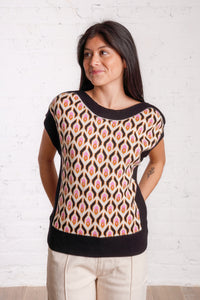Knitted sweater top with a multicolored retro pattern, and black borders. 