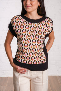 Knitted sweater top with a multicolored retro pattern, and black borders. 