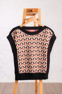 Knitted sweater top with a multicolored retro pattern, and black borders. 
