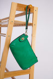 photo shows a green crossbody/ wristlet on a stand