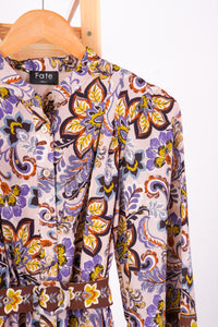 A long-sleeve button-front blouse with a floral and paisley print, hanging on a wooden hanger against a white background. The brand label 'Fate' is visible at the collar.