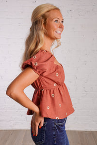 rust puff sleeve peplum top with embroidered flowers 