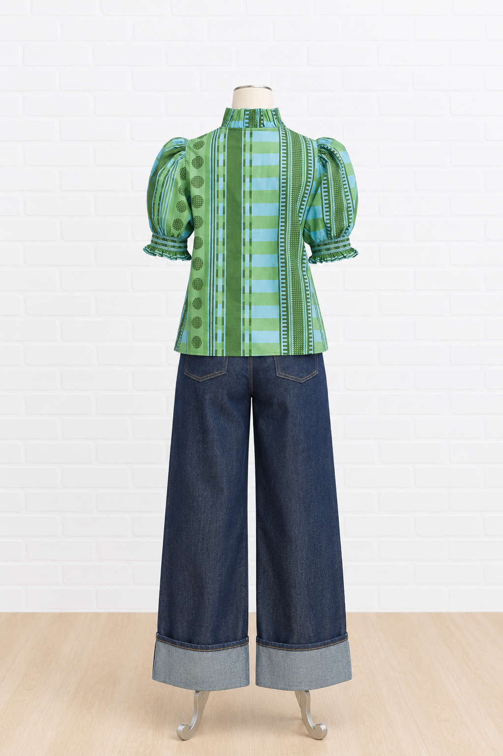A green and blue patterned puff-sleeve blouse displayed on a mannequin 