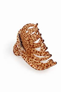 A tortoiseshell hair claw clip with a brown and tan spotted pattern