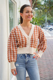 model is wearing a beige and brown houndstooth print cardigan