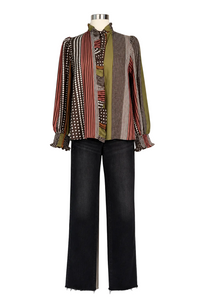 A patterned long-sleeve blouse with dark wide-leg jeans displayed on a mannequin against a plain white studio background.