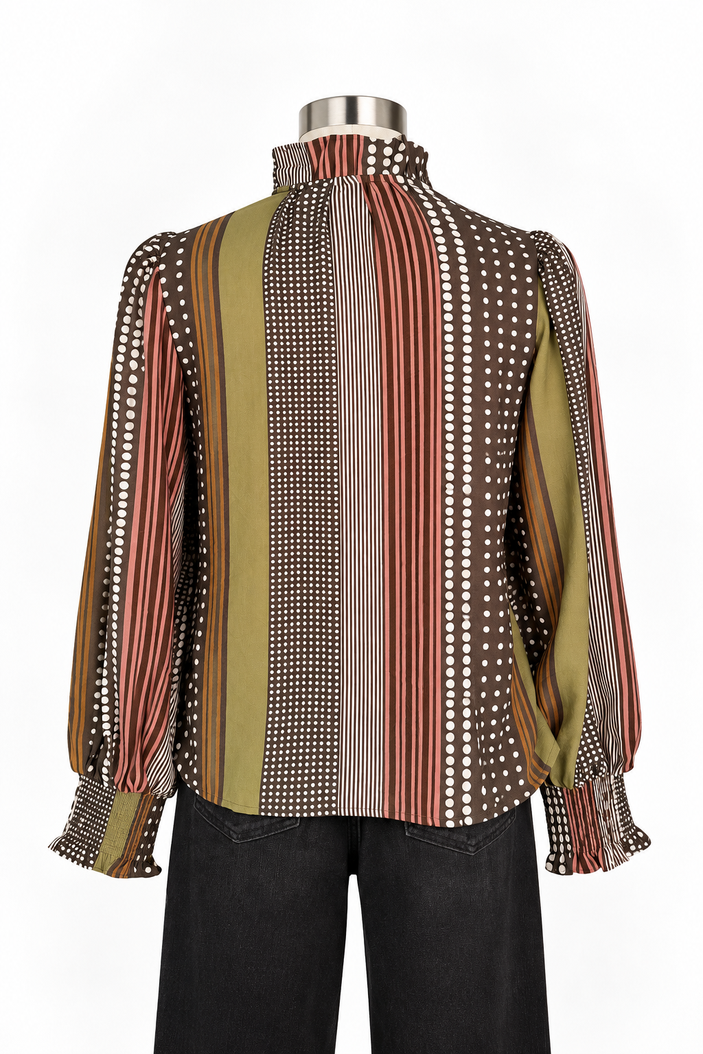 A long-sleeve mock neck blouse with vertical stripes and polka dots in brown, olive green, rust red, and white, displayed on a mannequin torso with black pants against a white background.