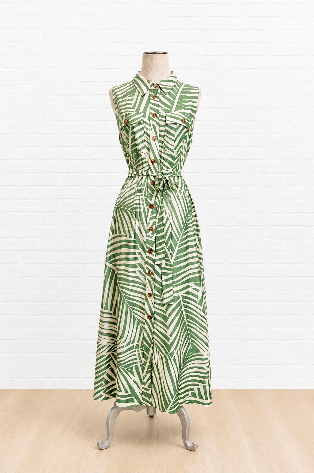 Green patterned dress on a mannequin against a white background