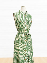 Green and white patterned dress on a mannequin against a white background