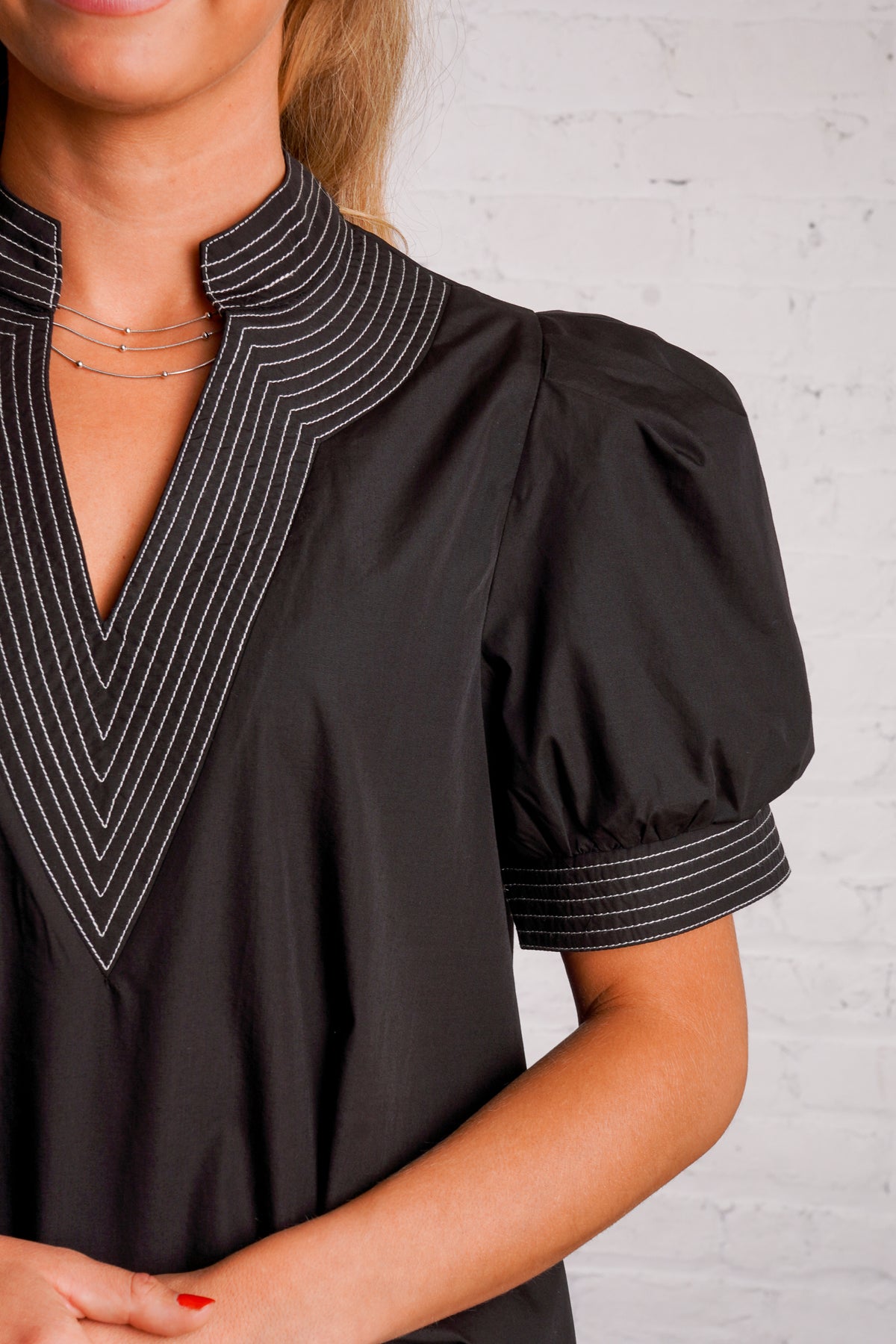 Black v-neck top with white stitching detail 