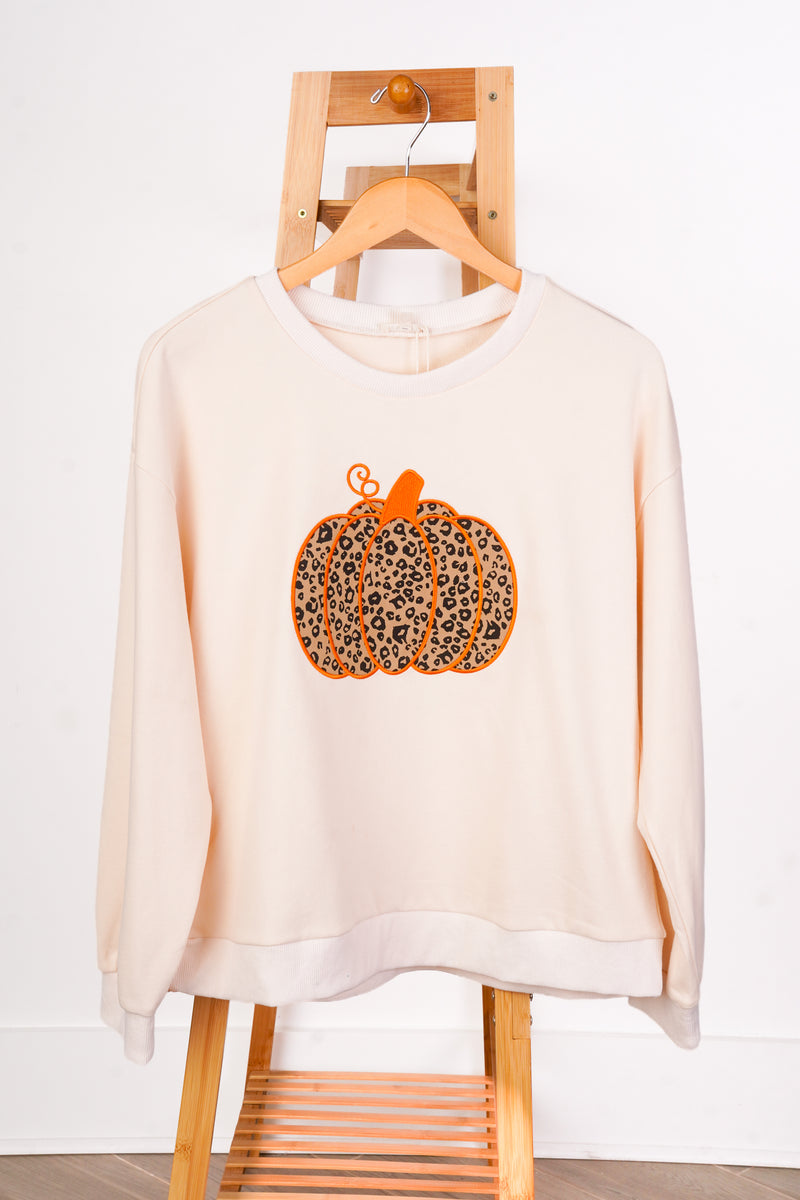 A cream-colored crewneck sweatshirt with a leopard-print pumpkin graphic on the front