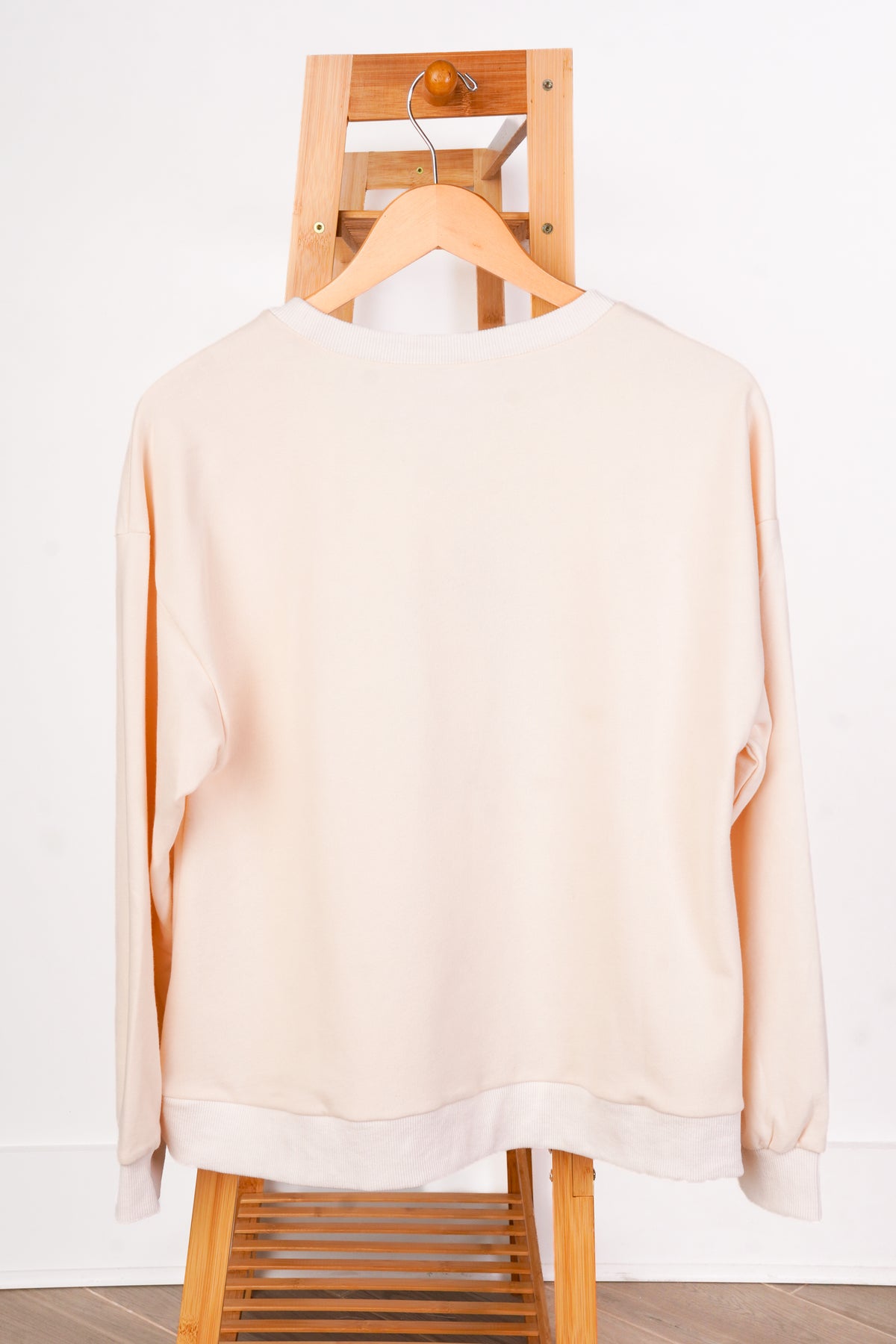 A cream-colored crewneck sweatshirt with a leopard-print pumpkin graphic on the front