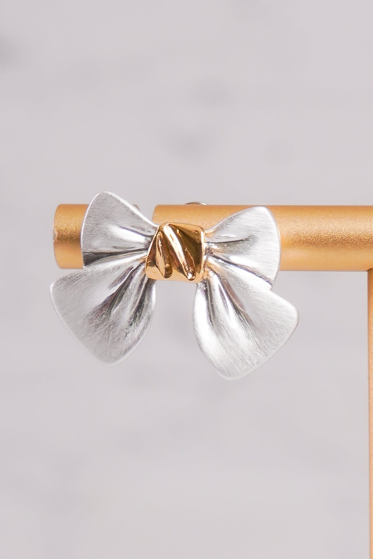Silver bow-shaped earrings with gold centers 