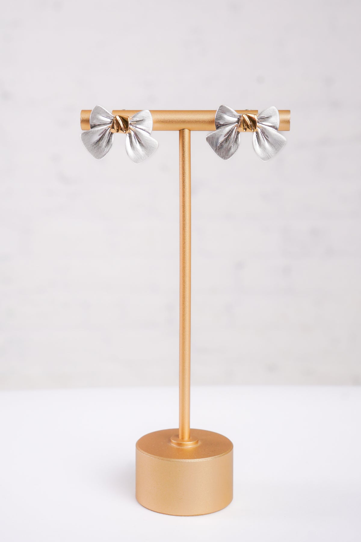 Silver bow-shaped earrings with gold centers 