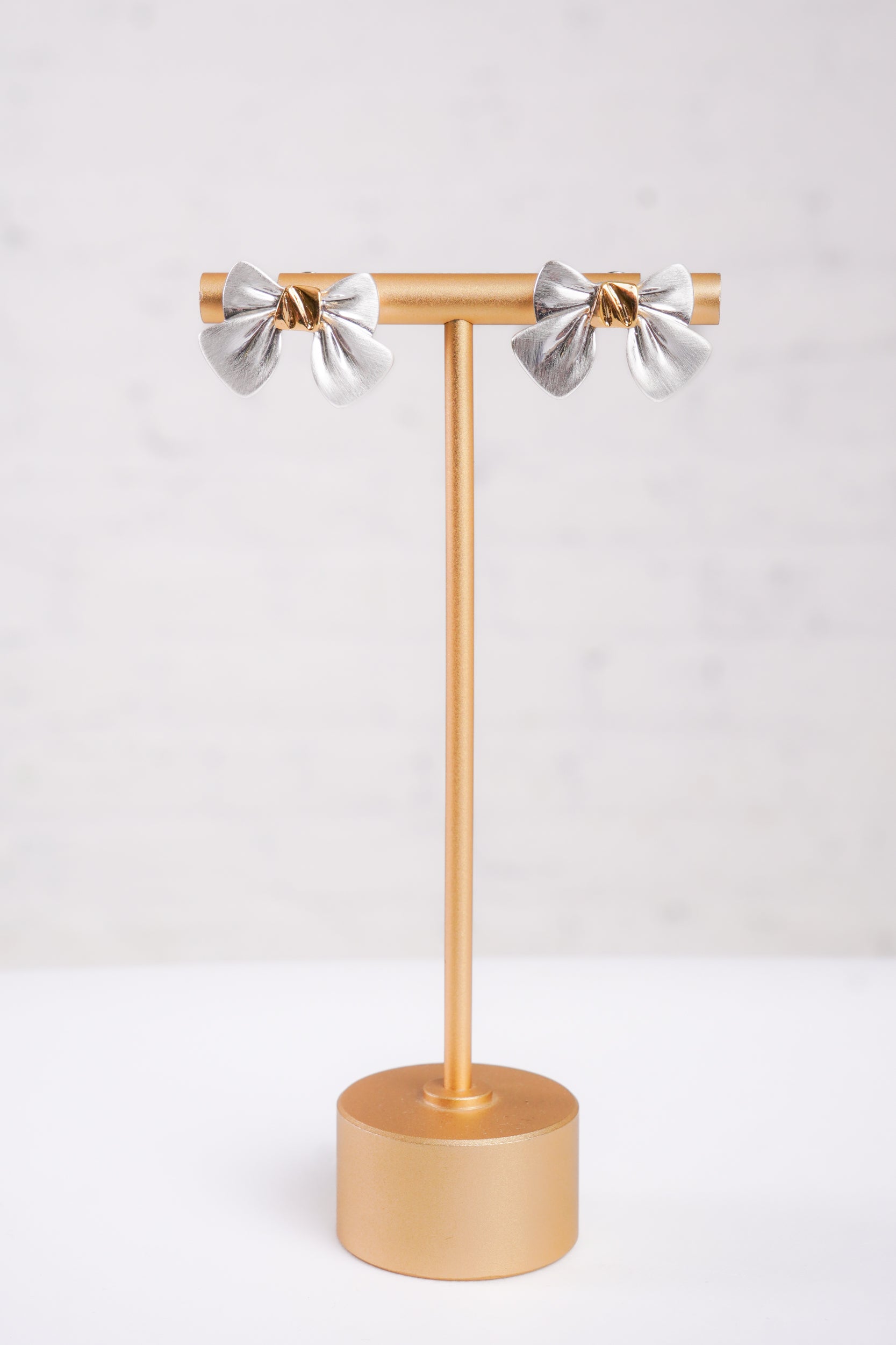 Silver bow-shaped earrings with gold centers 