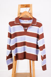 A long-sleeve knit polo-style sweater with horizontal brown, cream, and light blue stripes, displayed on a wooden hanger and stand against a plain white background.