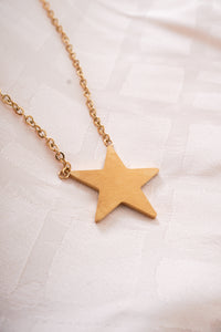 A necklace with a gold chain and a gold star on the chain