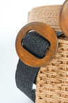 A black woven belt with a brown wooden circle buckle for closure. 