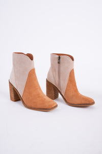 Photo shows a pair of color blocked booties in various neutral shades. 