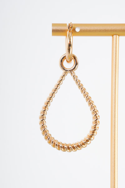 A gold earring that features a small gold hoop with an attachable gold twisted teardrop piece. The teardrop piece has a small circle that slides onto the hoop earring. The hoop piece has a clasp backing. 