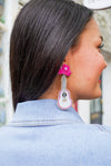 Model is wearing pink guitar shaped earrings