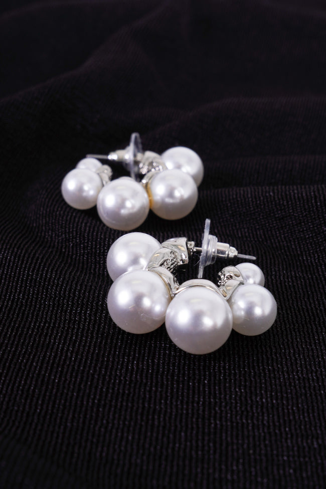 Photo shows a pair of small silver and pearl hoops. 