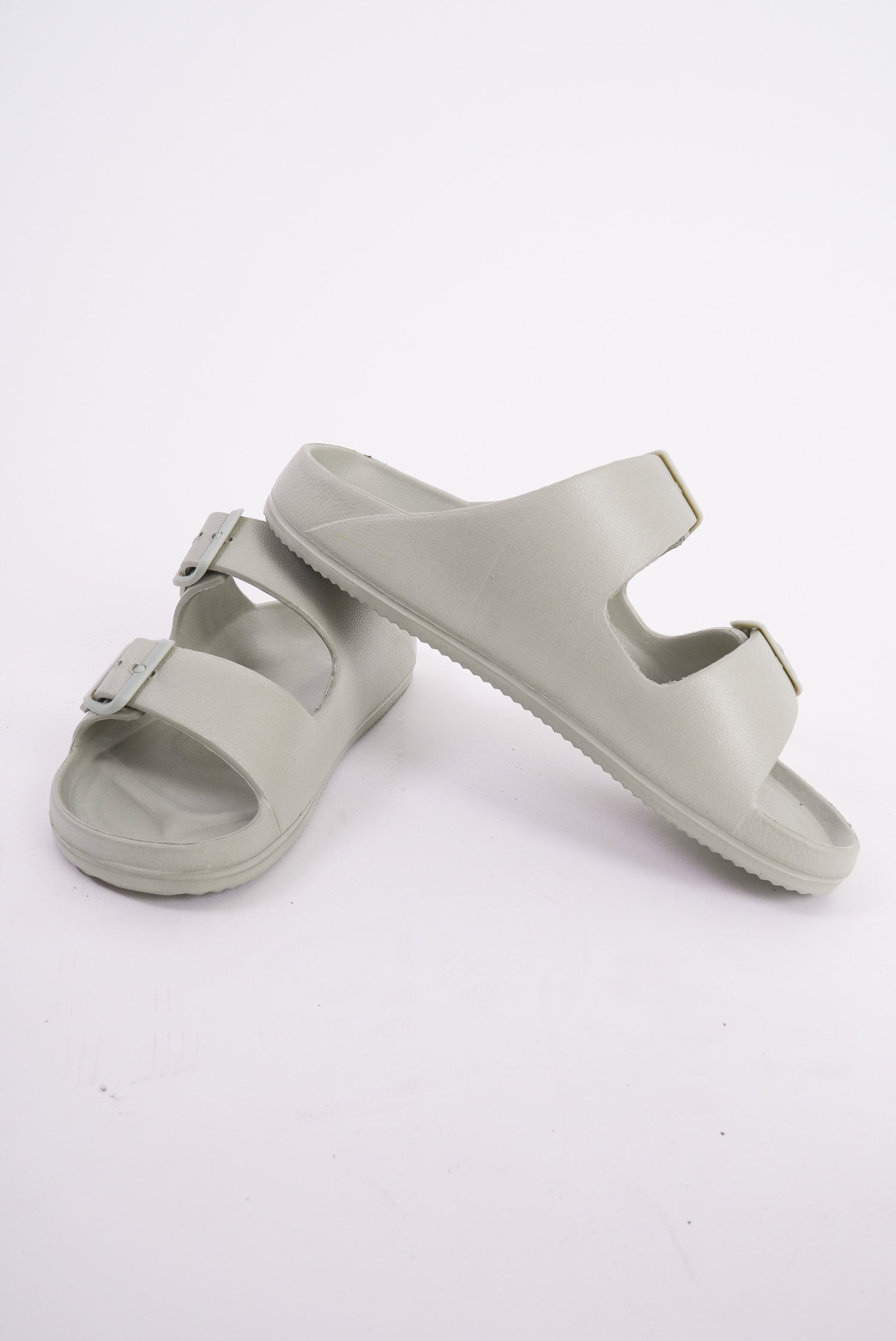 A pair of Birkenstock style sandals that are a sage green color. They have two adjustable straps that go across the top of the foot, are lightweight and are waterproof. 
