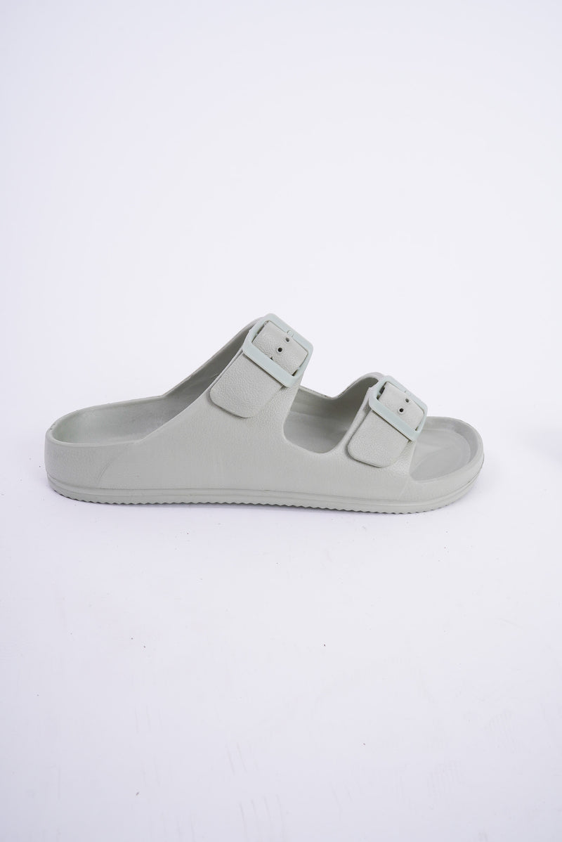A pair of Birkenstock style sandals that are a sage green color. They have two adjustable straps that go across the top of the foot, are lightweight and are waterproof. 