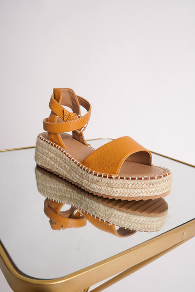 Photo shows a pair of tan espadrille wedges on a mirror